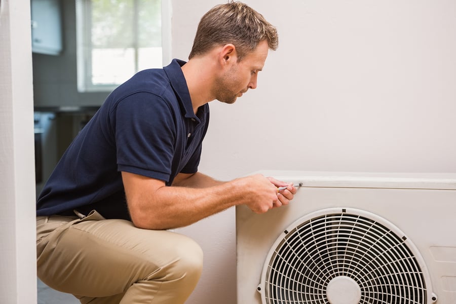 technician completing ac unit repair